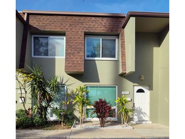 Tan two-story townhouse with white door, landscaping, and window blinds at 1330 70Th N St, St Petersburg, FL 33710