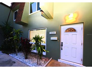 Inviting home exterior featuring a well-lit entrance, decorative door, and manicured landscaping at 1330 70Th N St, St Petersburg, FL 33710