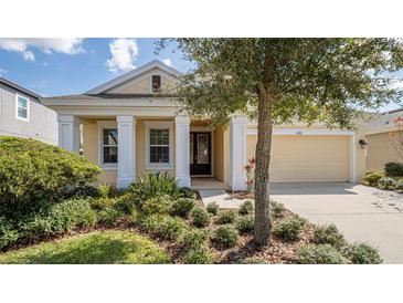 Inviting single-story home featuring manicured landscaping and a covered porch, perfect for relaxing outdoors at 1838 Tallulah Ter, Wesley Chapel, FL 33543