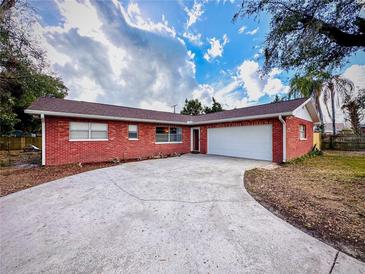 Brick ranch home with attached garage and a long concrete driveway at 222 Mary Ellen Ave, Seffner, FL 33584