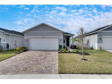 Gray house with white garage door and landscaped yard at 2584 89Th Street E Cir, Palmetto, FL 34221