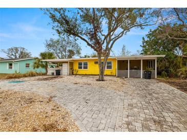 Bright yellow house with a large front yard and paved driveway at 2812 Miriam S St, Gulfport, FL 33711