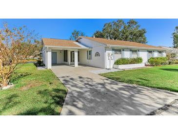 White single story home with carport and mature landscaping at 2243 Greenwich Dr, Sun City Center, FL 33573