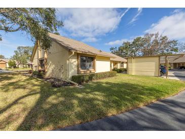 Exterior view of a single-story home with carport, landscaping, and a paved driveway at 2530 Oakleaf Ln # 31A, Clearwater, FL 33763