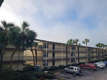 Two-story condo building with parking and tropical landscaping at 14130 Rosemary Ln # 6214, Largo, FL 33774