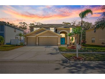 Two-story house with a three-car garage and landscaped yard at 15815 Muirfield Dr, Odessa, FL 33556