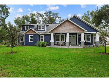 Charming craftsman style home with a spacious front yard and blue exterior at 1707 E Park Cir, Tampa, FL 33610