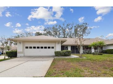 Single-story home with attached garage and landscaped lawn at 9214 Golf View Dr, New Port Richey, FL 34655