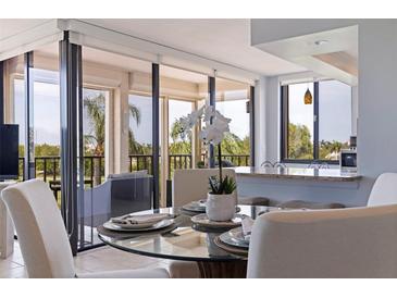Condo dining area with glass table, off-white chairs, and balcony view at 6104 Palma Del Mar S Blvd # 404, St Petersburg, FL 33715