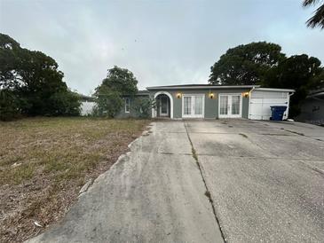House exterior with driveway and yard at 6947 Bottle Brush Dr, Port Richey, FL 34668