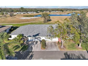 Aerial view of single-story home with two-car garage, situated on a golf course at 1312 Leland Dr # 61, Sun City Center, FL 33573
