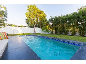 Relaxing rectangular pool with dark gray coping and blue tile at 2246 Fiesta Dr, Sarasota, FL 34231