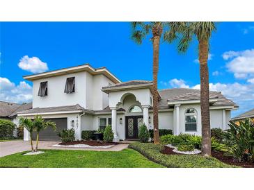 Two-story house with white exterior, gray garage door, and palm trees at 4687 Alisa Ne Cir, St Petersburg, FL 33703