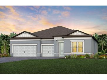 Two-story home with gray exterior, three-car garage, and landscaped lawn at 6136 Jensen View Ave, Apollo Beach, FL 33572