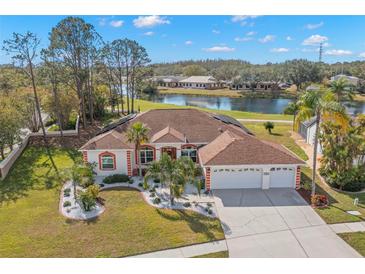 Single-story home with a two-car garage, mature landscaping, and a pond view at 3702 Gaviota Dr, Ruskin, FL 33573