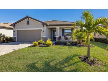 Single-story home with a two-car garage, landscaping, and a paved driveway at 5211 Marina Basin Ct, Bradenton, FL 34211