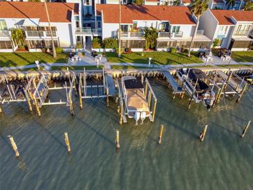 Aerial view of waterfront property with boat slips and private docks at 175 Medallion Blvd # F, Madeira Beach, FL 33708