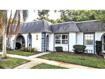Charming light-grey exterior condo with well-maintained landscaping and walkway at 4214 Trucious Pl, New Port Richey, FL 34652