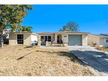 Ranch-style house with a single-car garage and a spacious front yard at 9836 Rainbow Ln, Port Richey, FL 34668