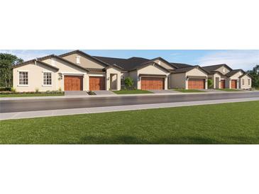 Exterior view of charming townhouses with attached garages and lush landscaping at 17175 Tortoise Crown Blvd, Land O Lakes, FL 34638