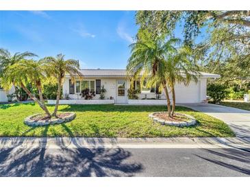 White single story home with palm trees and well-manicured lawn at 14198 89Th Ave, Seminole, FL 33776