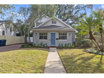 Gray house with blue door, landscaped lawn, and walkway at 3616 W Morrison Ave, Tampa, FL 33629