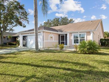 Cute Florida home with palm trees, well-maintained lawn, and attached garage at 4303 Waltham Ln, New Port Richey, FL 34653