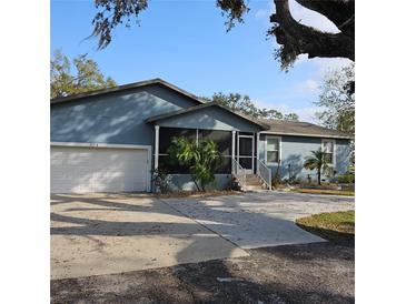 Ranch style home with attached garage, screened porch, and mature landscaping at 604 8Th Sw St, Ruskin, FL 33570