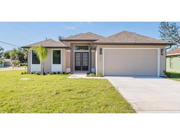 New construction home with a two-car garage and attractive landscaping at 112 Sidney Ct, Rotonda West, FL 33947