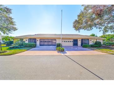 Front view of two-unit building, each with a garage and landscaped grounds at 1526 Leland Dr # 1525, Sun City Center, FL 33573
