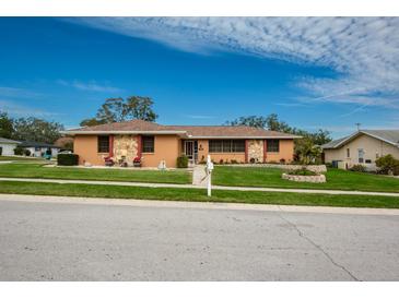 Single story home with stone accents, landscaped yard, and a two car garage at 153 Sunward Ave, Palm Harbor, FL 34684