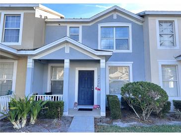 Two-story townhome with blue and beige exterior, landscaping, and a walkway at 9822 Carlsdale Dr, Riverview, FL 33578