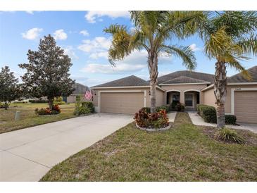 Two-story house with a two-car garage and landscaped front yard at 13627 Crest Lake Dr, Hudson, FL 34669