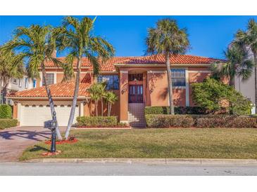 Two-story house with tile roof, attached garage, and manicured lawn at 207 8Th E St, St Petersburg, FL 33715