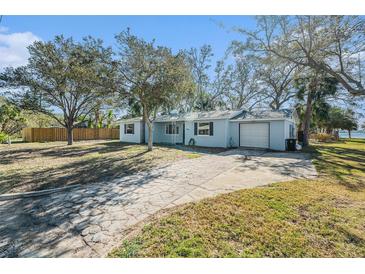 Light blue house with a white garage door and a spacious yard at 4824 Trade Winds S Dr, Gulfport, FL 33711