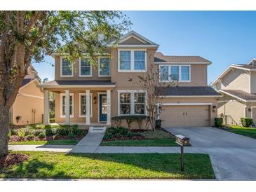 Two-story house with beige exterior, landscaping, and a two-car garage at 5935 Parkset Dr, Lithia, FL 33547