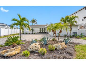A waterfront home with palm trees and a paved driveway at 65 Dolphin Dr, Treasure Island, FL 33706