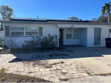 Ranch-style home with solar panels and a paved driveway at 246 94Th N Ave, St Petersburg, FL 33702