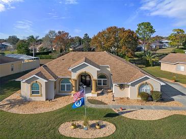 One-story home with a landscaped yard and a three-car garage at 3363 Cedar Crest Loop, Spring Hill, FL 34609