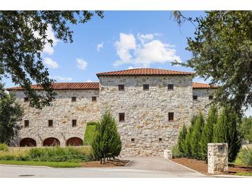 Stone exterior of a two-story home with a tile roof and lush landscaping at 1571 Oceanview Dr, St Petersburg, FL 33715