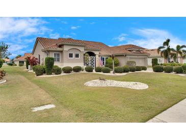 One-story house with tile roof, well-manicured lawn, and mature shrubs at 2003 Captiva Ct, Sun City Center, FL 33573
