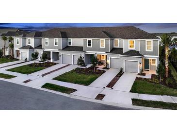 New townhome community with attached garages and lush landscaping at 2123 Hallier Cv, Wesley Chapel, FL 33543