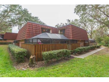 Brick townhouse with red tile roof, screened patio, and fenced yard at 2601 2Nd Ct, Palm Harbor, FL 34684