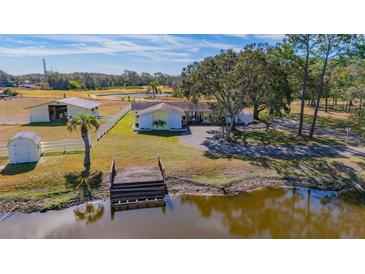 Aerial view of a home on acreage with a pond, barn, and private dock at 3050 Maple Trce, Tarpon Springs, FL 34688