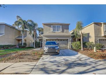Two-story house with attached garage and palm trees at 15521 Long Cypress Dr, Ruskin, FL 33573