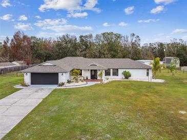 Single story house with a large yard and attached garage at 25555 Oaks Blvd, Land O Lakes, FL 34639