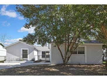 Newly renovated home with a fenced backyard and a large tree in front at 3332 Vorden St, New Port Richey, FL 34655
