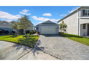 Two-story house with gray exterior and a paved driveway at 34104 White Fountain Ct, Wesley Chapel, FL 33545