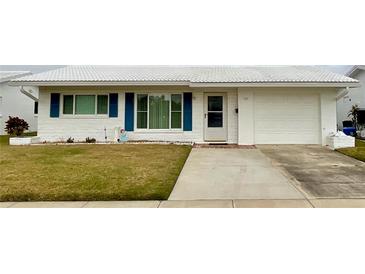 White single story home with blue shutters, attached garage, and small front yard at 3425 96Th N Ter # 4, Pinellas Park, FL 33782