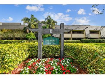 Building exterior showcasing landscaping and signage for Muirfield Lodge 15 at 36750 Us Highway 19 N # 15118, Palm Harbor, FL 34684